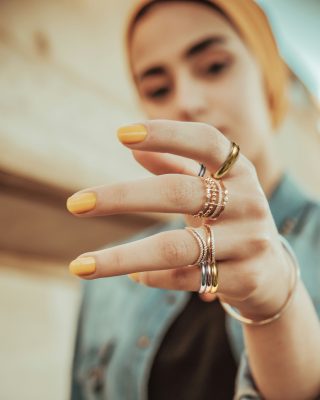 Ragazza con mano con anello su ogni dito. Indossa uno dei nostri gioielli online,Trilogy &Eacute;clat - set di anelli in acciaio inossidabile al dito mignolo